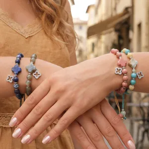 Gedetailleerd uitzicht op modieuze edelsteen armbanden met elegante klaverblad-hangers.