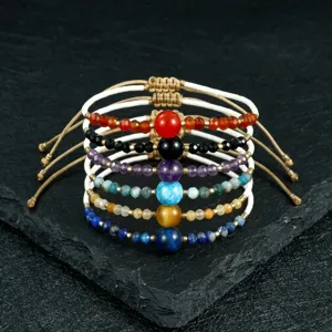 Close-up detail shot of handmade chakra beaded bracelets with colorful gemstone beads and cords.