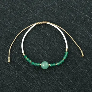 Handmade woven beaded bracelet detail, green stone and white miyuki beads, adjustable cord.