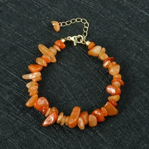 Details van de oranje onregelmatige edelsteen armband met stijlvolle gouden verlengketting.