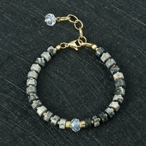 Detailfoto van de grijs halfedelsteen kralen armband voor dames met gouden metalen kralen.
