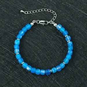 Close-up detail van een blauwe gefacetteerde kralenarmband met zilveren verlengketting.
