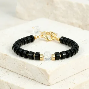 Elegant zwarte kralenarmband met centrale heldere kristal en gouden spacers voor dames.