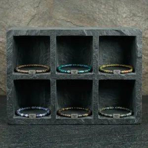 Gedetailleerd overzicht van 4mm natuurstenen kralenarmbanden in diverse kleuren op leisteen.