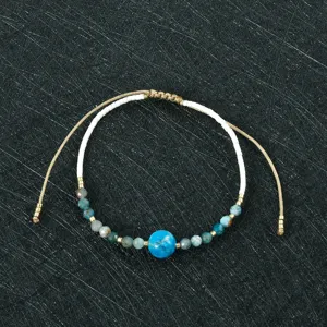 Handmade beaded bracelet with white seed beads and blue gemstone charms for women.