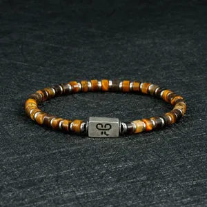 Detailopname van een modieus heren 4mm tigerogen kralen armband met een metalen element.