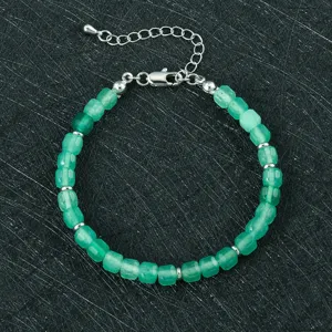 Groene gefacetteerde stenen kraal armband met zilverkleurige metalen sluiting en ketting.