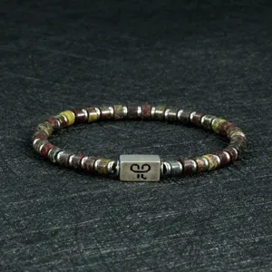 Close-up detail van een 4mm edelsteen en metalen kraal armband met gegraveerd middenstuk.