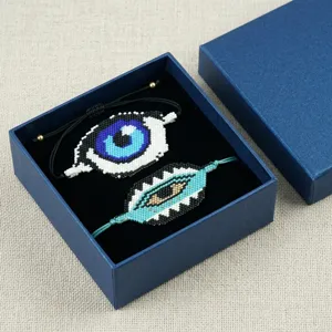Dettaglio in primo piano di bracciali con perline Miyuki malocchio in scatola blu.