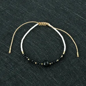 Detailed view of handmade woven beaded bracelet with Miyuki beads and black stones.