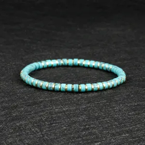 Detailed view of bohemian turquoise heishi bead stretch bracelet with gold spacers.