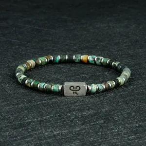 Gedetailleerd overzicht van een 4mm edelsteenkralen armband met stijlvolle metalen bedel.