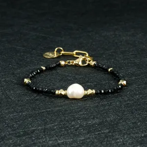 Modieuze minimalistische zwarte agaat kralenarmband met onregelmatige zoetwaterparel en slot.