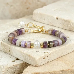 Kortbij opname van kleurrijke toermalijn kralen armband details met kristal op natuursteen.