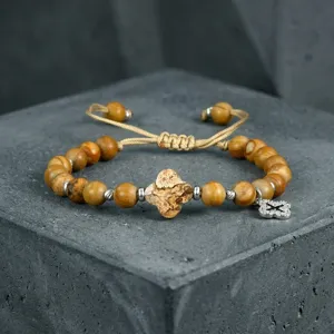 Detailopname van de geweven stenen kralen armband met klaverbladhanger en verstelbaar koordje.