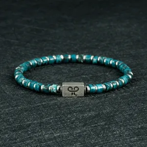 Gedetailleerd overzicht van turquoise-achtige kralenarmband met metalen spacers.