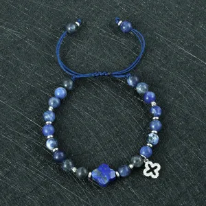 Detailopname van de modieuze lapis lazuli geweven armband met charmante klaverbladmotieven.