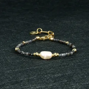 Minimalistische zwarte agaat kraalarmband met onregelmatige zoetwaterparel en mooie gouden accenten.