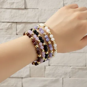 Detailopname van de stijlvolle meerlaagse kralenarmband met halfedelstenen en gouden kralen.