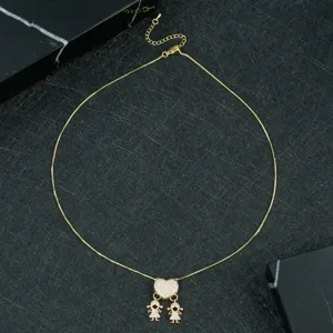 Gold-plated heart pendant necklace with cute double girl charms detail close-up shot