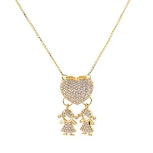Detail view of a gold-plated heart and twin girls pendant necklace sparkling with cubic zirconia.