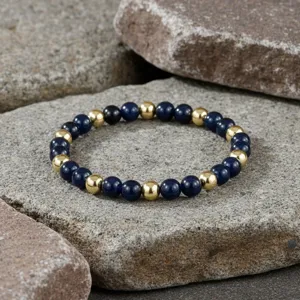 Detailopname van vintage kralenarmband met donkerblauwe edelstenen en gouden metalen kralen.