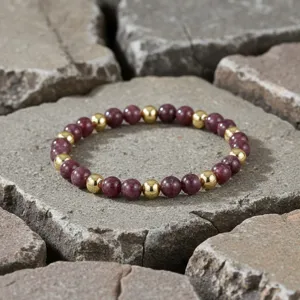 Gedetailleerde close-up van de kralenarmband met paarse stenen en gouden kralen.