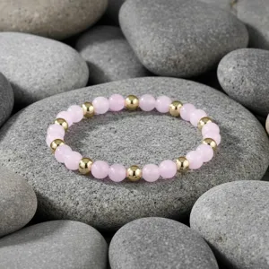 Gedetailleerde close-up van de roze edelsteen kraal armband met elegante gouden afstandhouders.