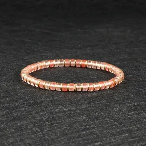 Detail shot of pink crystal bead bracelet with metal spacers on dark slate background.