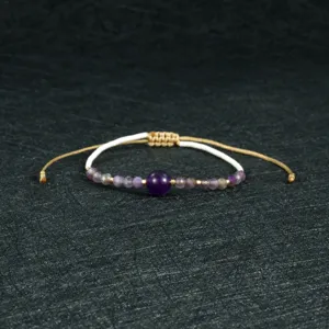 Handmade woven beaded bracelet detail shot, elegant purple gemstone style with adjustable cord.