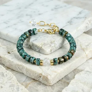 Close-up detail van de groene halfedelsteen kralenarmband met gouden tussenstukken en kristal kralen.