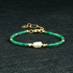 Groene gefacetteerde kralen en barokparel armband met gouden metalen details en bedel.