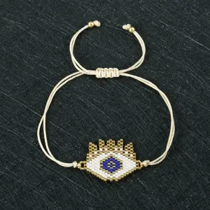 Dettaglio in primo piano del braccialetto con occhio blu in perline miyuki regolabile.