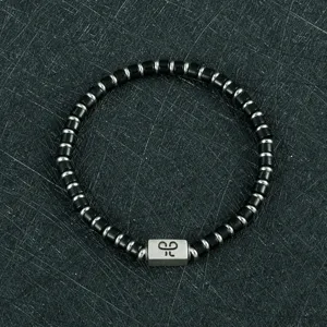 Gedetailleerd overzicht van de stijlvolle heren kralenarmband met zwarte cilinders.