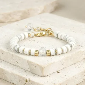 Detailopname van de witte stenen kralen armband met gouden spacers en helder kristal.