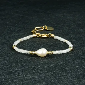Gedetailleerde close-up van de elegante parel- en kralenarmband met delicate gouden afstandhouders.