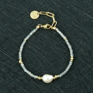 Gedetailleerd overzicht van mode kralenarmband met barokke parel en goudkleurige metalen bedels.