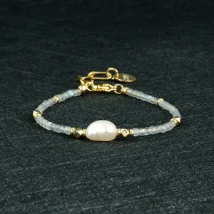 Minimalistische barok parelarmband met gouden metalen accenten en gefacetteerde kraaltjes.