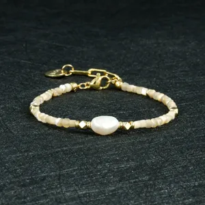 Gedetailleerd shot van een elegante parelarmband met gouden accenten en verlengketting.