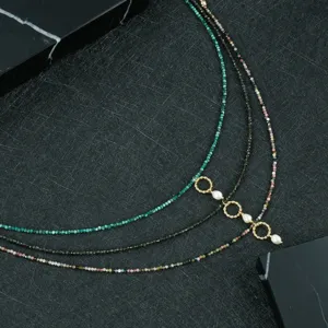 Collana vintage multistrato di perle e pietre preziose con perle d'acqua dolce e anelli d'oro.