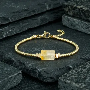 Gold beaded bracelet with natural yellow crystal stone detail view, elegant retro wrist jewelry.