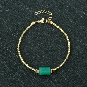 Detailed close-up of the green stone beaded bracelet, featuring metallic gold beads and clasp.
