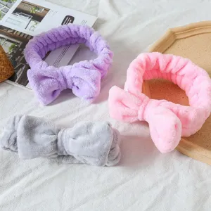 Close-up of soft fluffy bow headbands in purple, pink, and grey for spa and daily skincare routine.