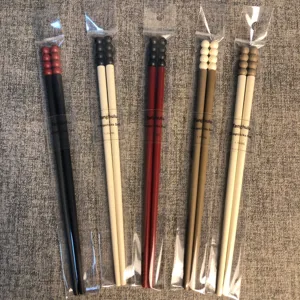 Detalle en primer plano de juegos de palillos estilo Tanghulu en envase individual transparente.