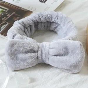 Grey plush bow headband detail view, soft spa face washing hair band for daily skin care routine.