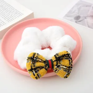 White plush hair scrunchie with tweed bow and retro striped accent for women fashion.