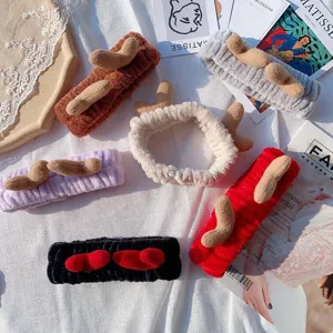 Detailed shot of cute plush antler headbands in multiple colors, soft coral fleece for makeup.