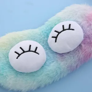 Rainbow plush sleep mask detail close-up, soft fluffy material with cute 3d embroidered eyes.
