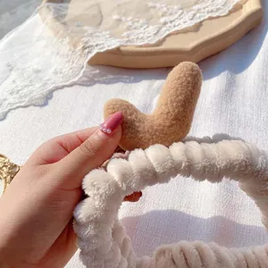 Plush antler hairband detail shot, soft coral fleece material for daily makeup and facial washing.