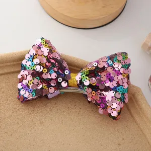 Vue rapprochée détaillée d'une pince à cheveux colorée nœud à paillettes, accessoire étincelant.